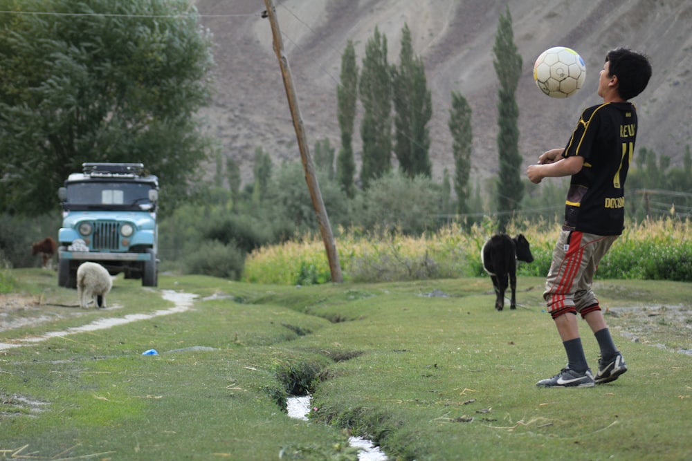 a young boy is playing with a soccer ball