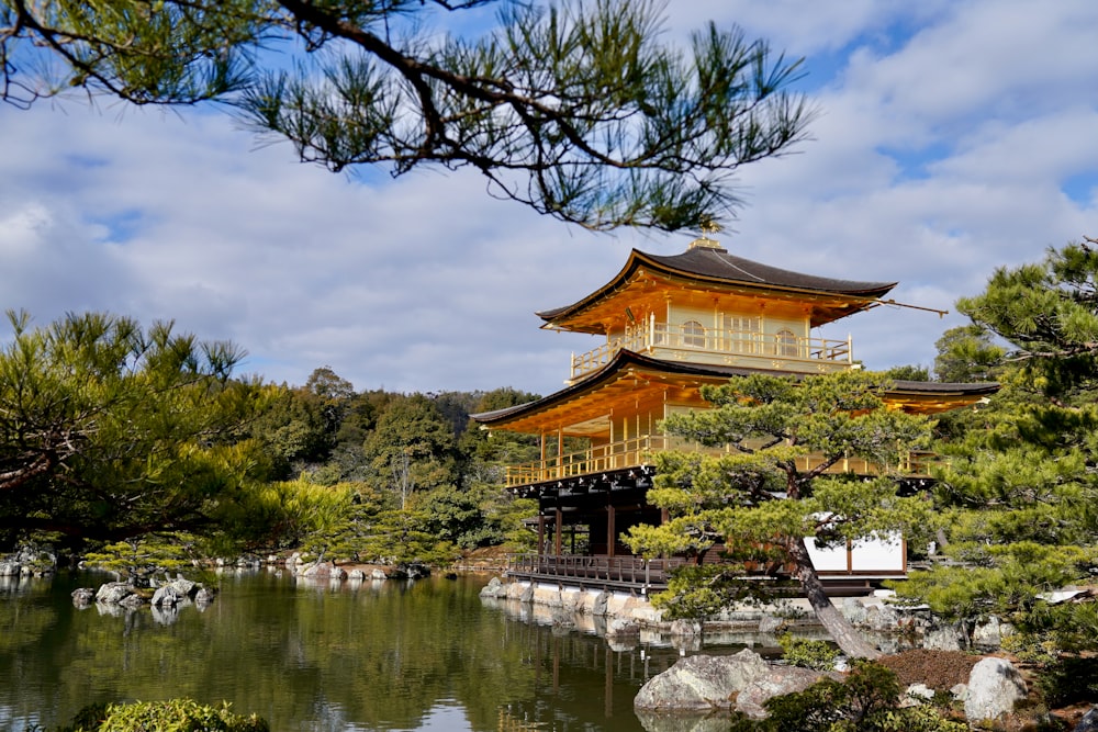 a pagoda in the middle of a pond surrounded by trees