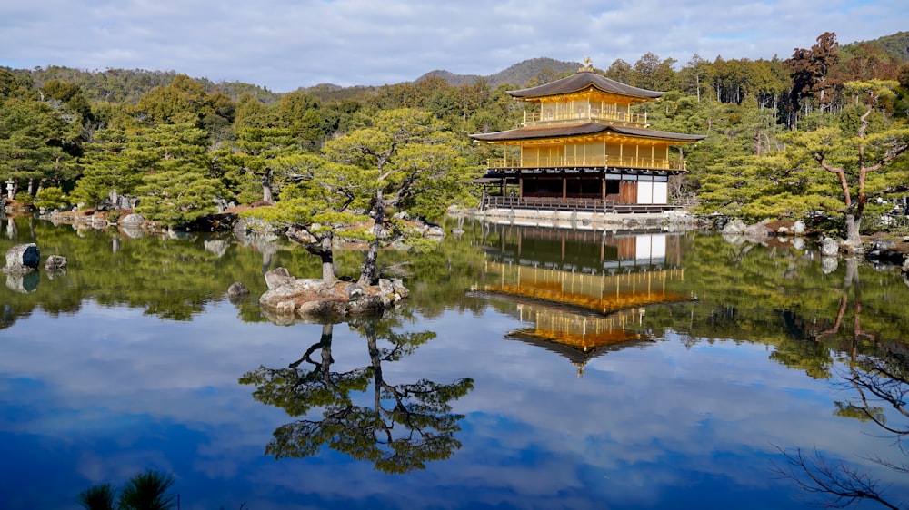 a pagoda in the middle of a lake surrounded by trees