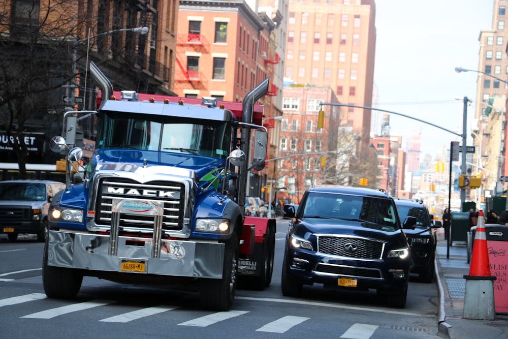 a truck driving down a street next to a car