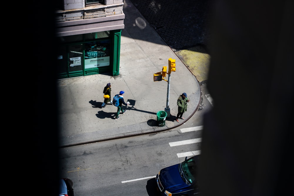 a group of people walking down a street next to a traffic light