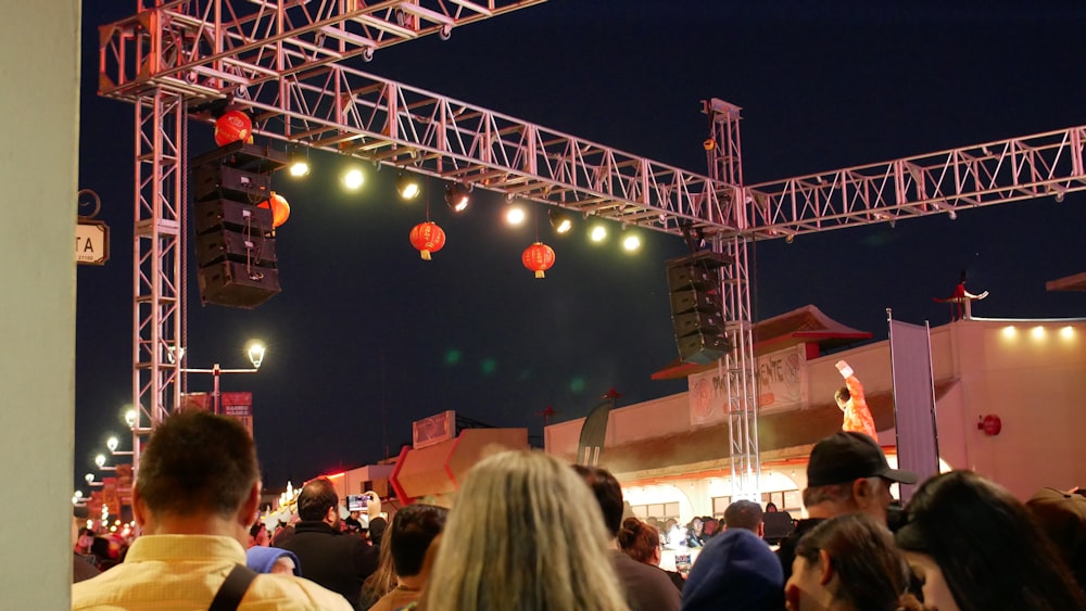 a crowd of people standing around a stage