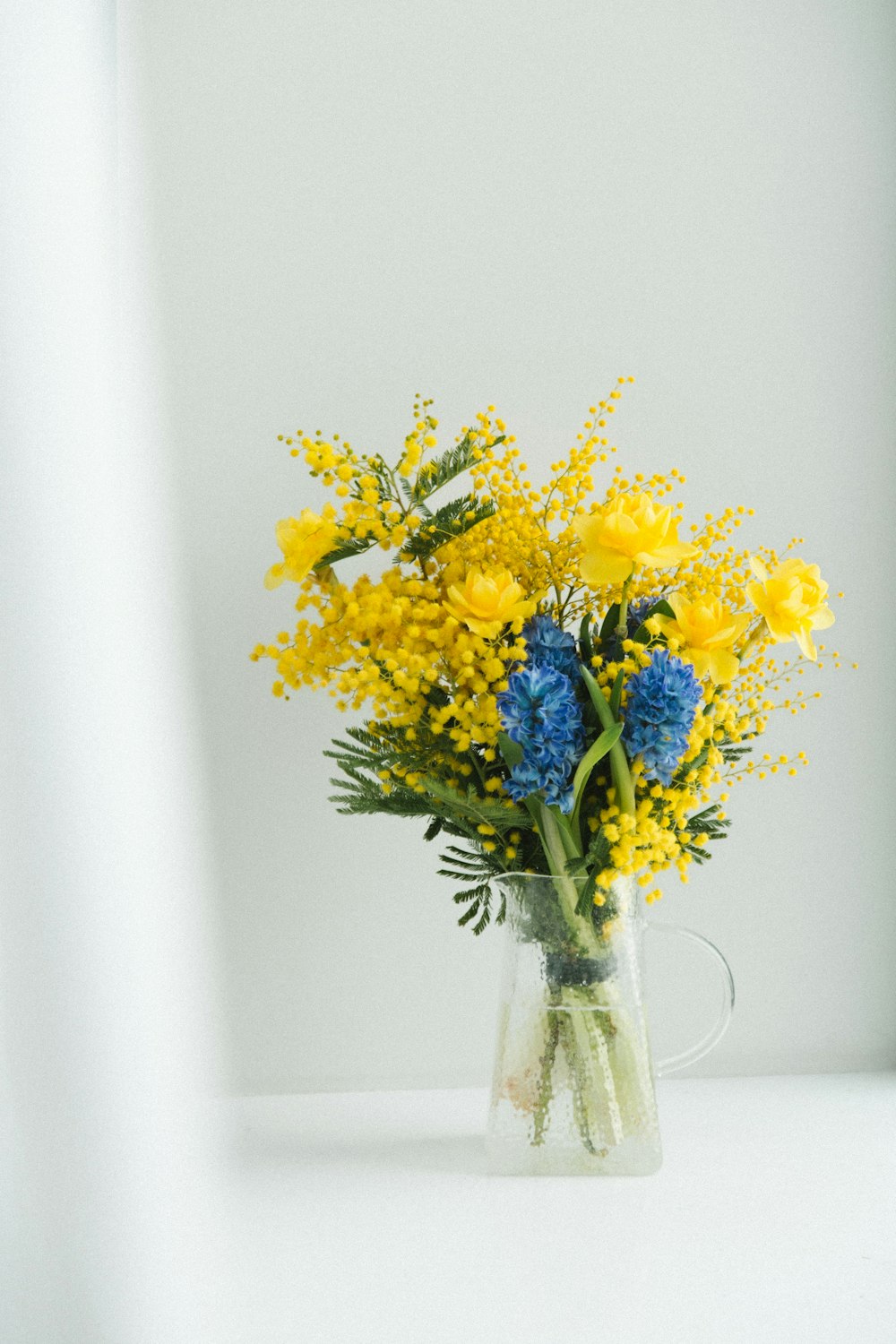 a vase filled with yellow and blue flowers