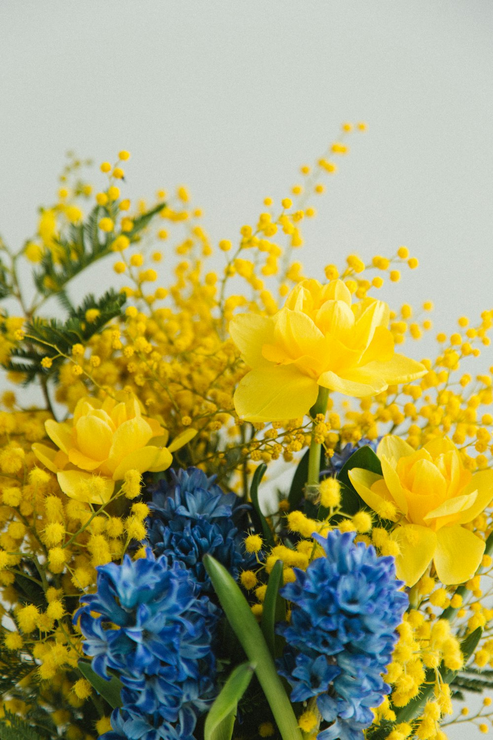 a vase filled with yellow and blue flowers