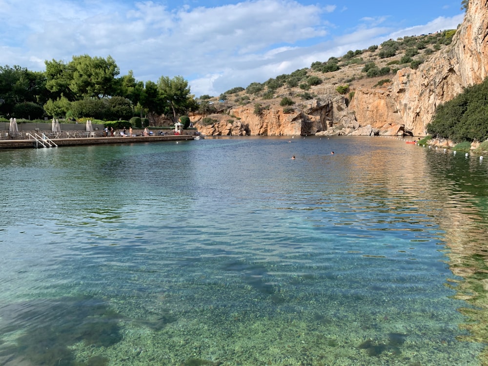 a body of water with a cliff in the background