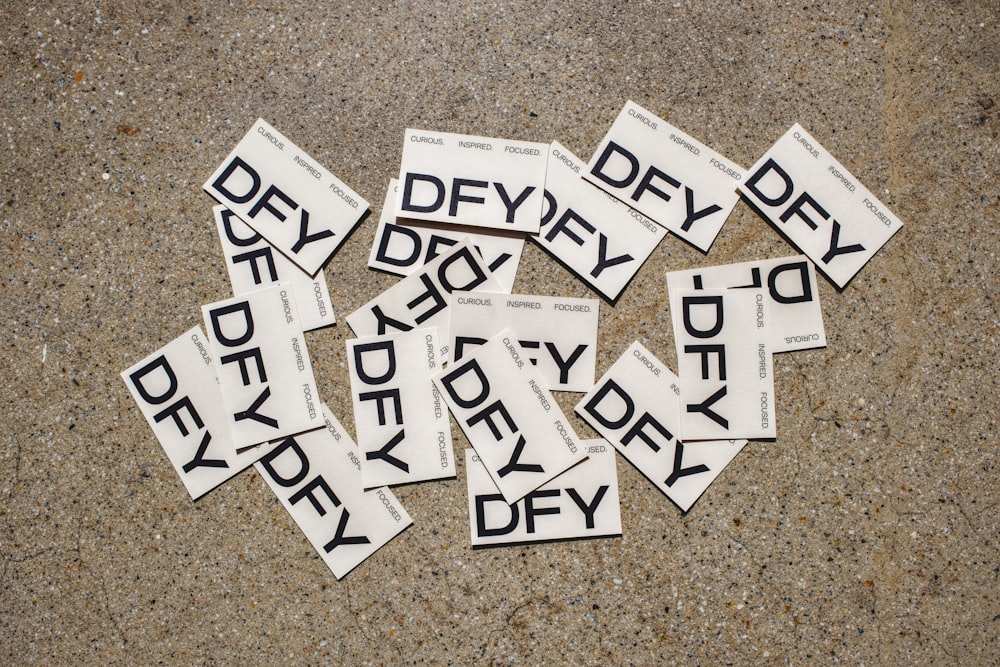 a pile of black and white stickers sitting on top of a floor