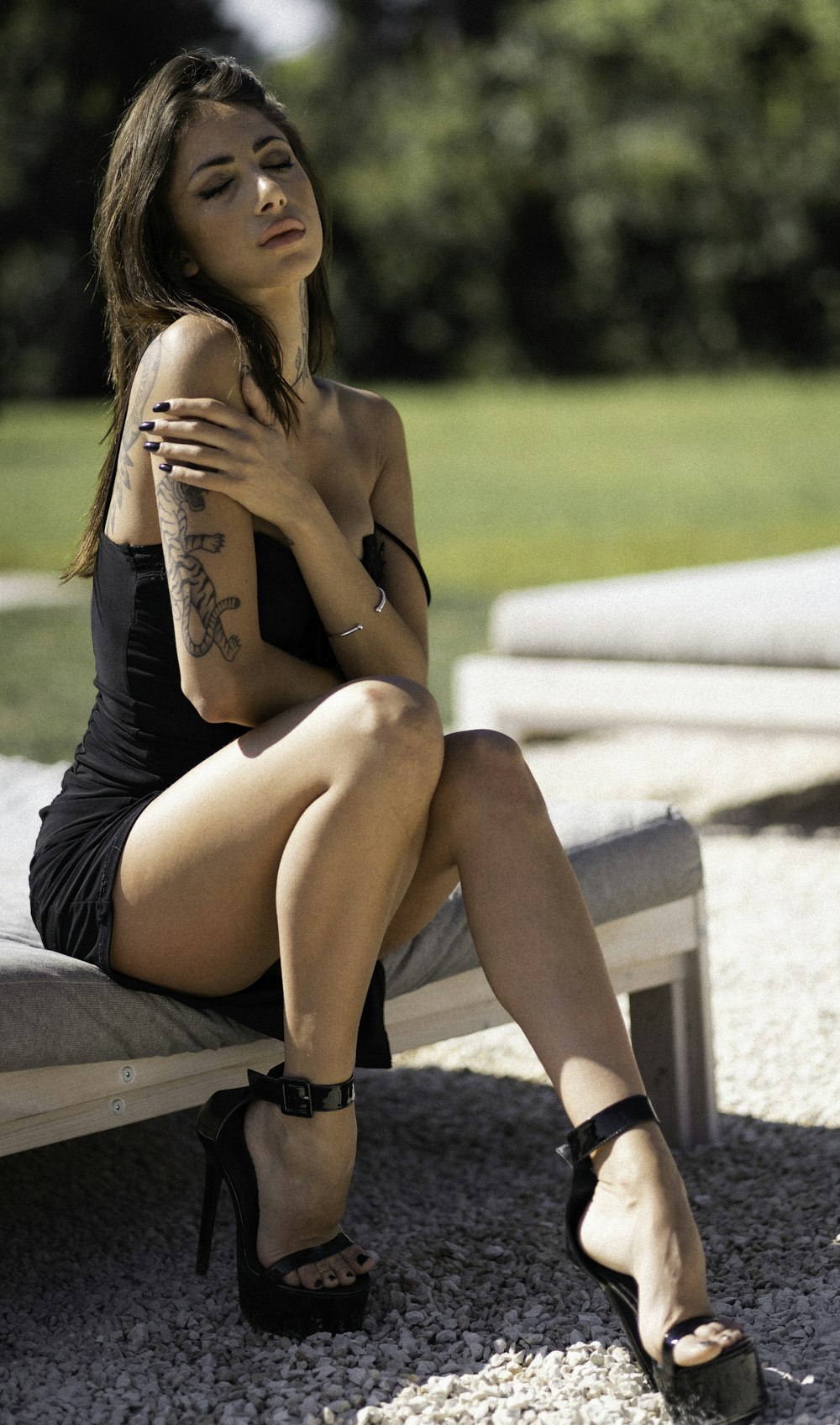 una donna seduta su una panchina in un vestito nero