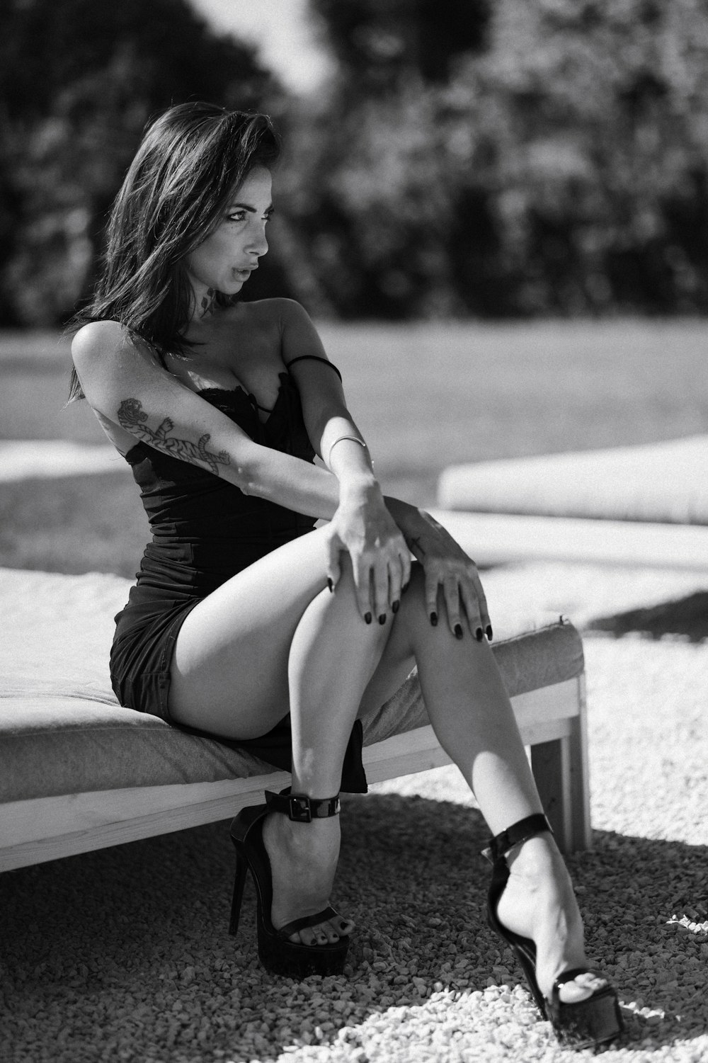 a black and white photo of a woman sitting on a bench