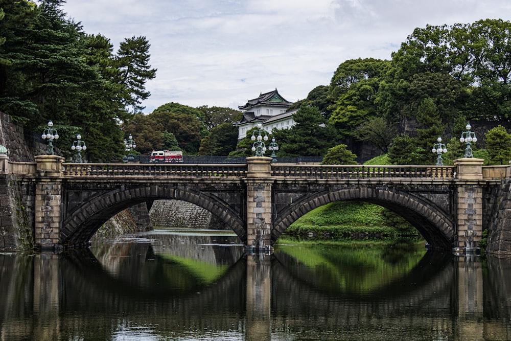 uma ponte sobre um corpo de água com um edifício ao fundo