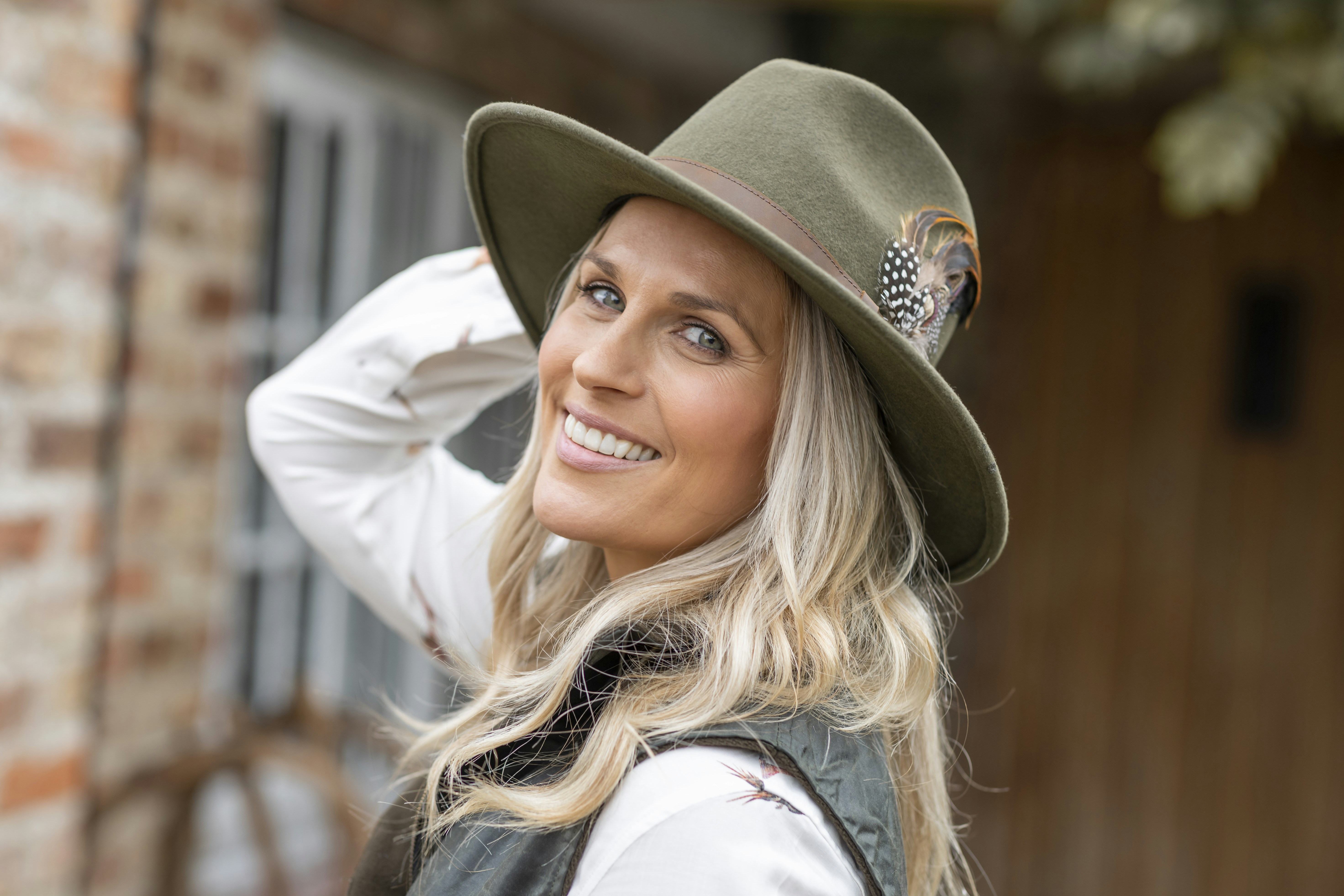 a woman wearing a green hat and vest