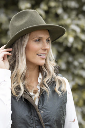 a woman wearing a green hat and vest