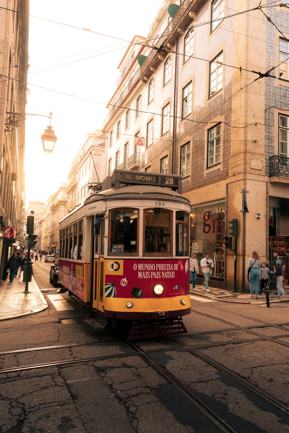 a red and yellow trolley on a city street