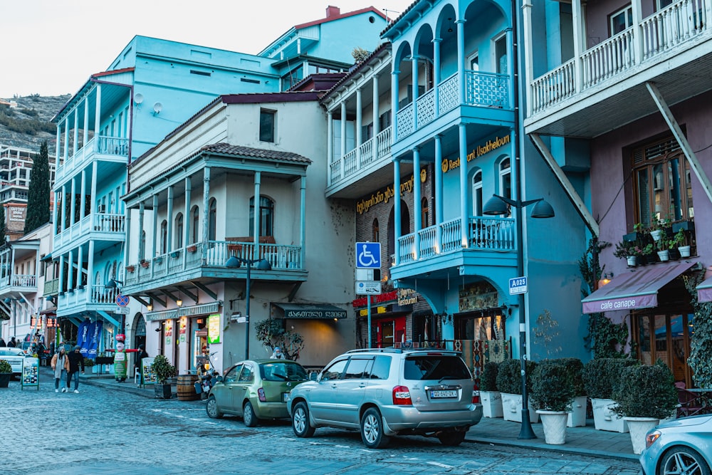 a row of buildings with cars parked on the side of the street