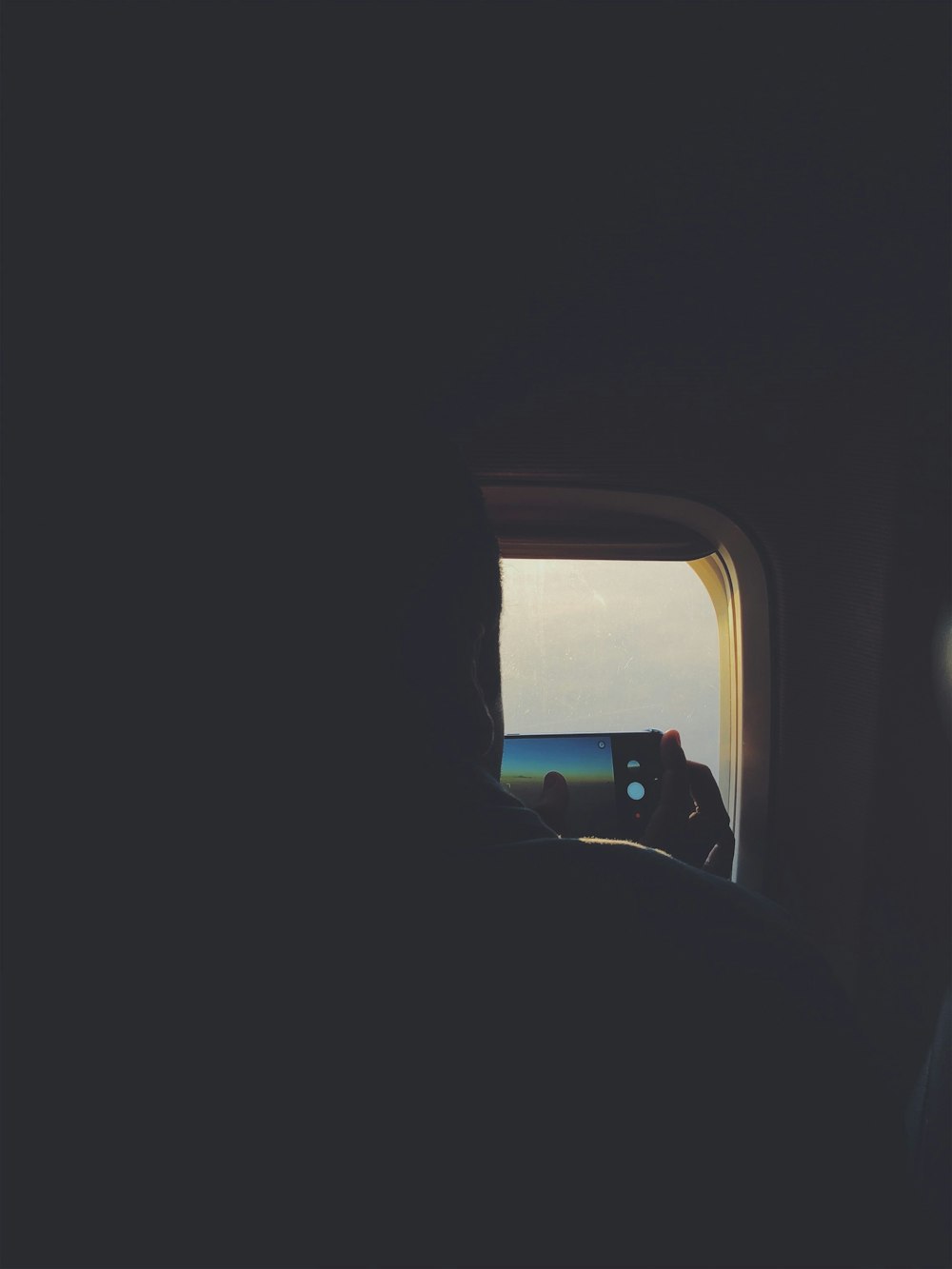 a person taking a picture of the ocean from an airplane window