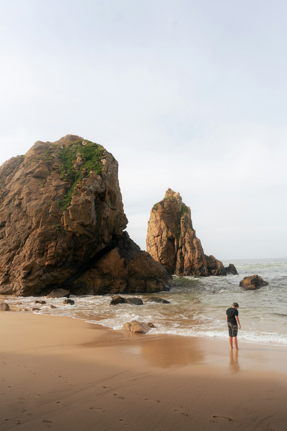 una persona parada en una playa junto al océano