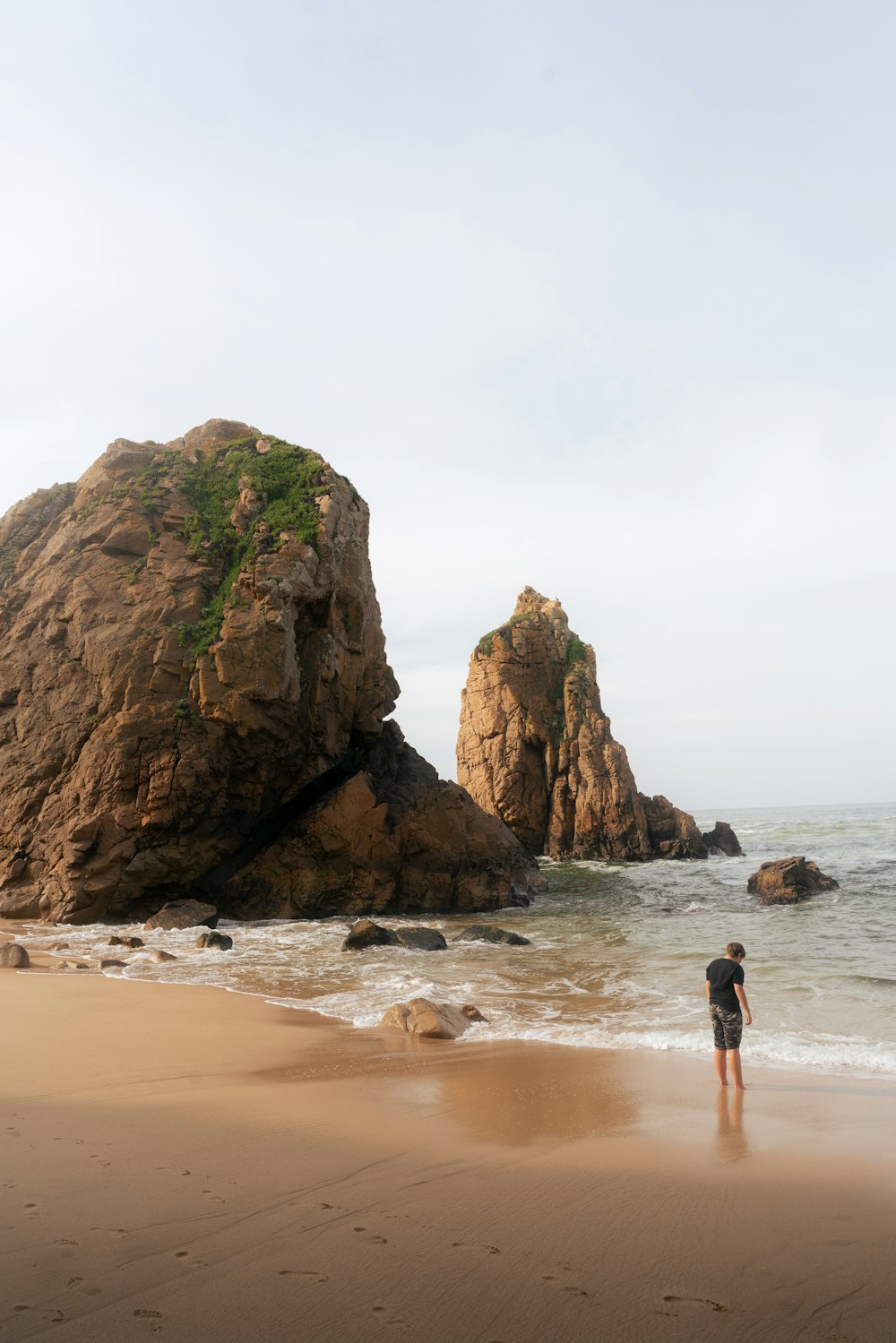 a person standing on a beach next to the ocean