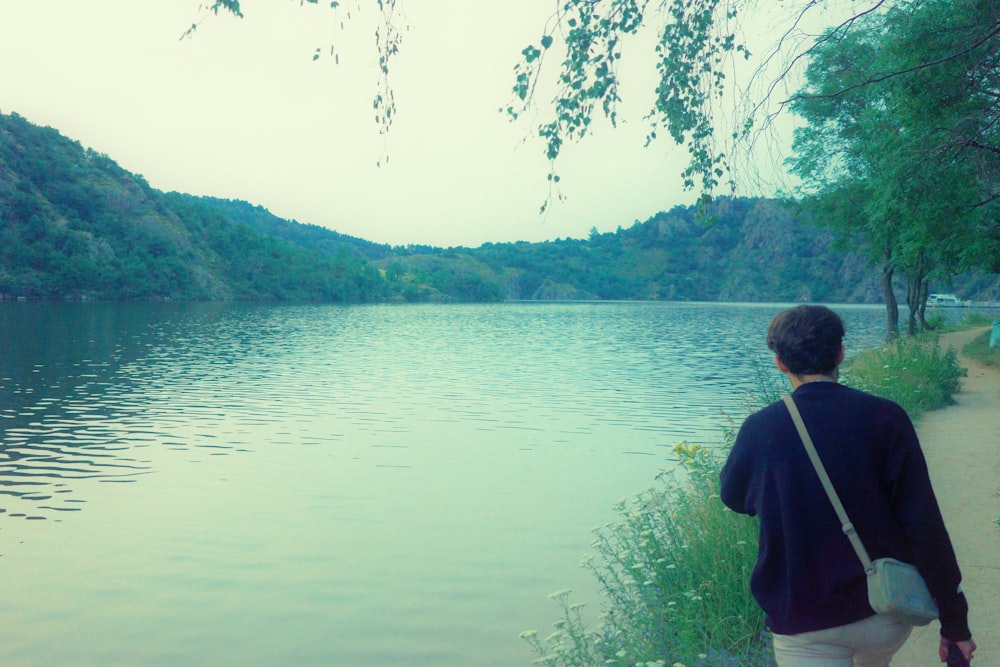 a person standing on a path near a body of water