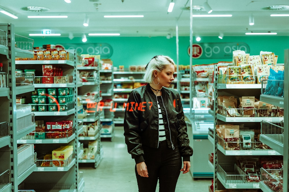 a woman standing in the aisle of a grocery store