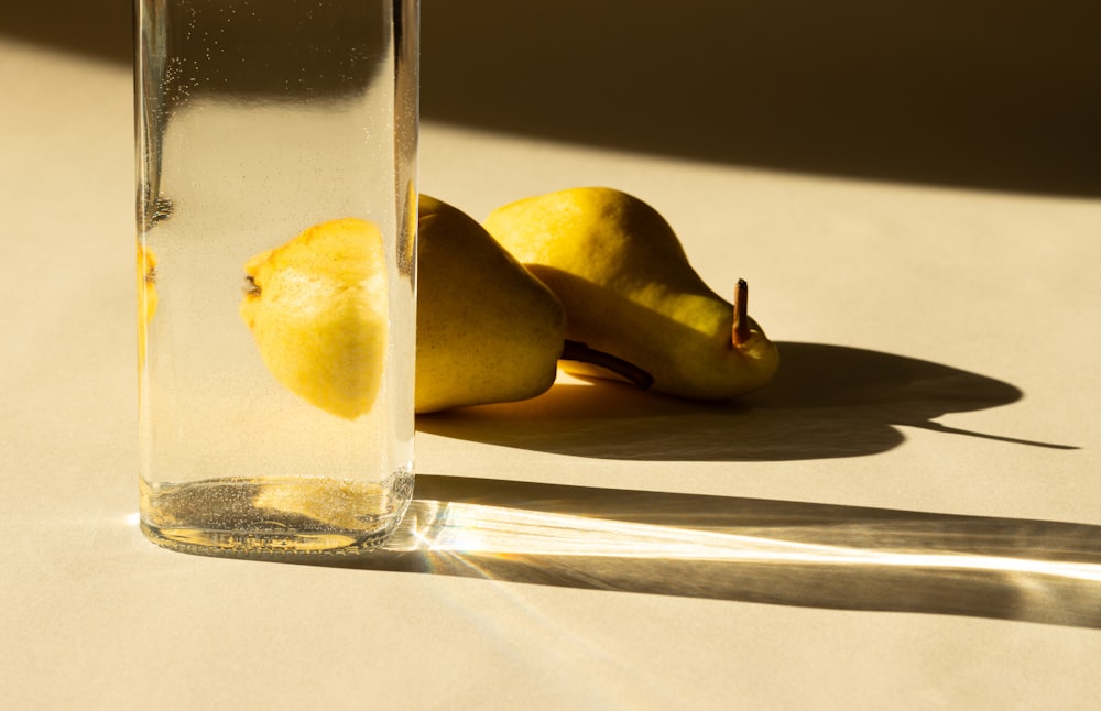 two pears and a glass of water on a table