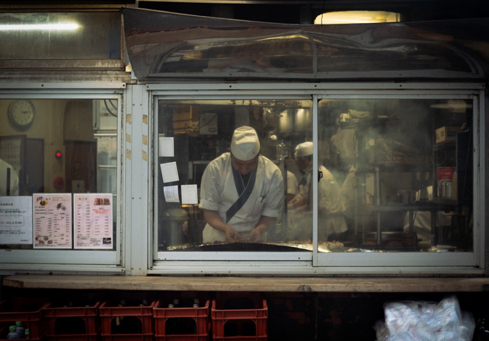 a man working in a kitchen behind a window
