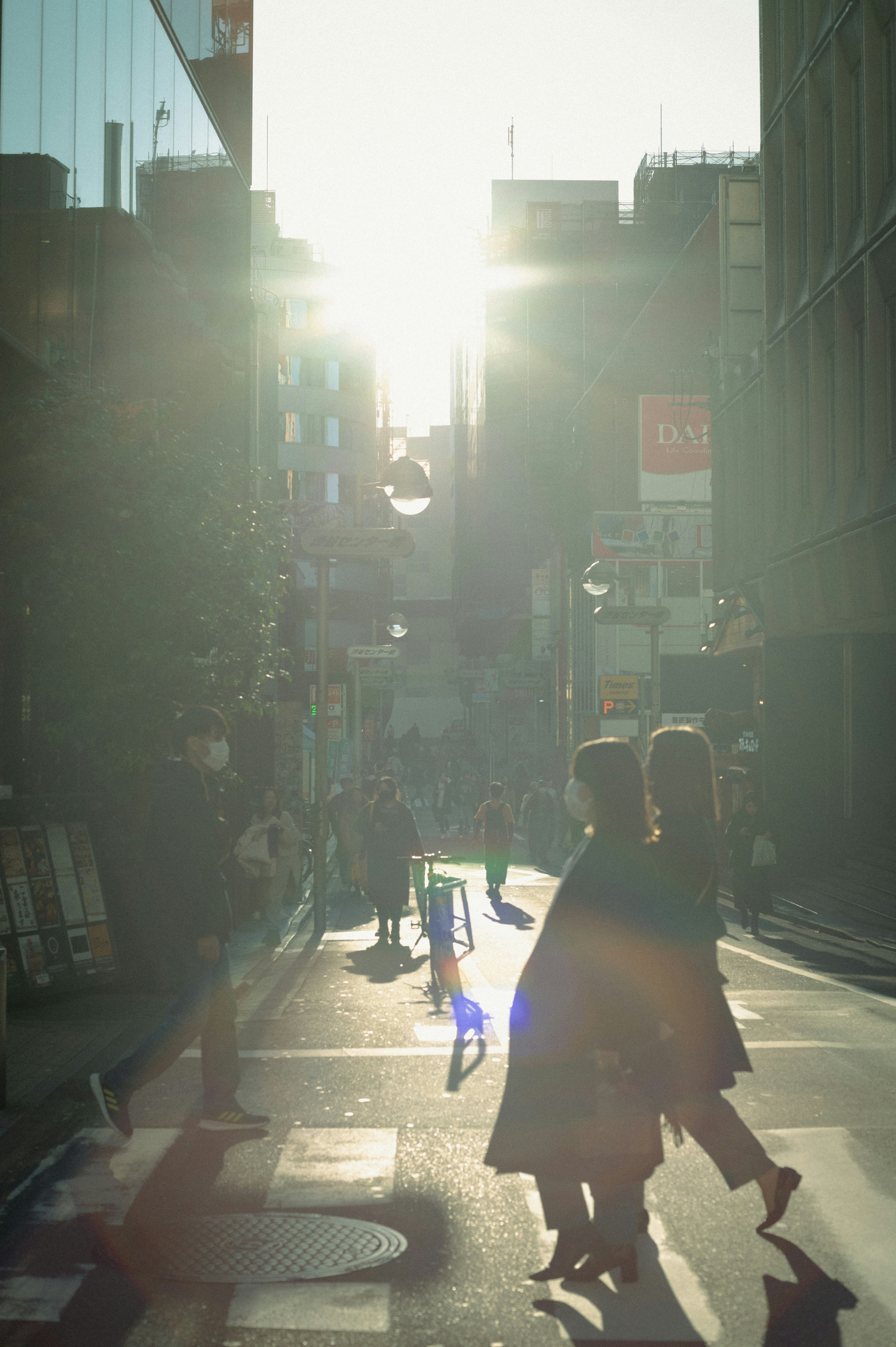 高層ビルの隣の通りを歩いている人々のグループ