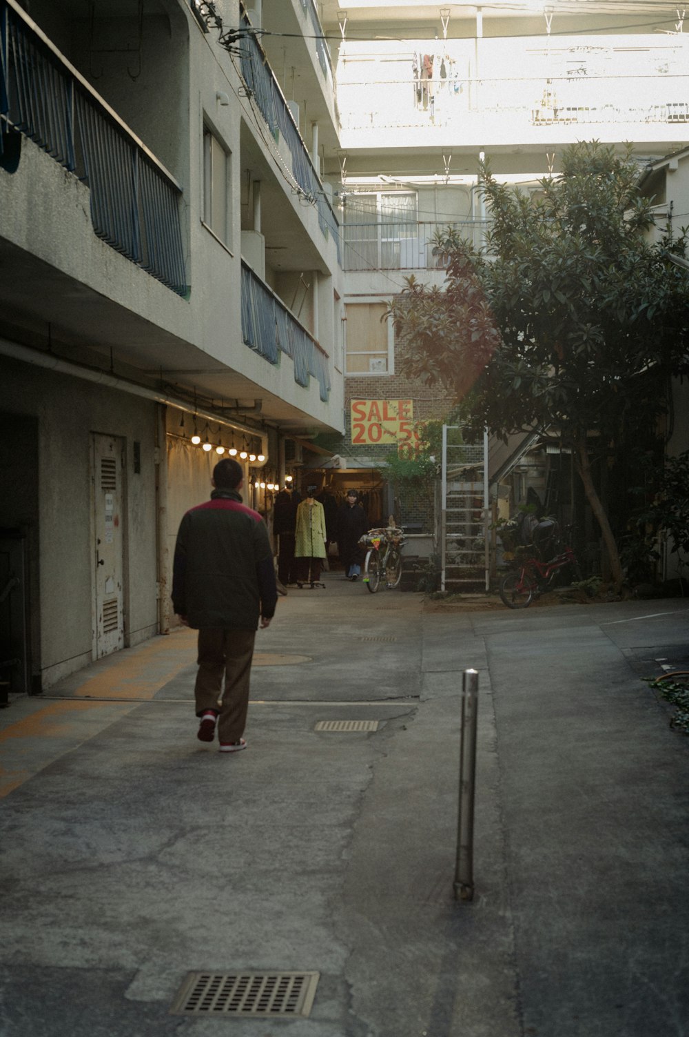 a man walking down a street next to a tall building