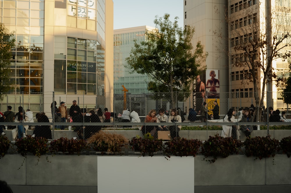 a group of people standing on a sidewalk next to tall buildings