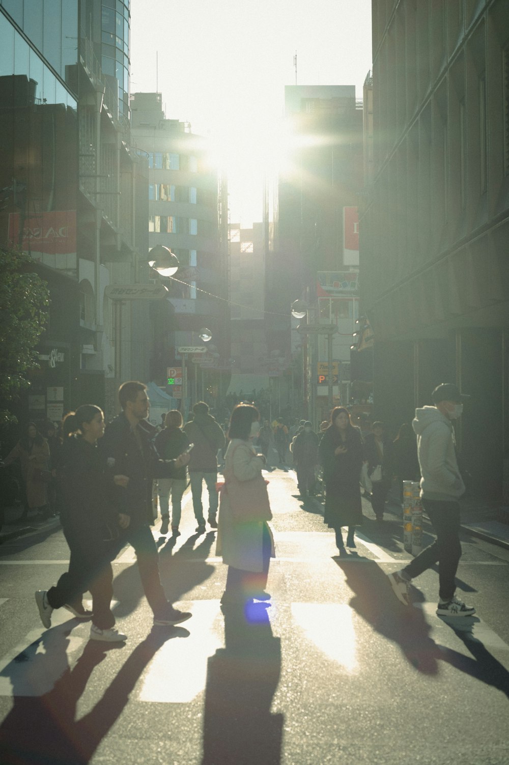 Un grupo de personas caminando por una calle junto a edificios altos