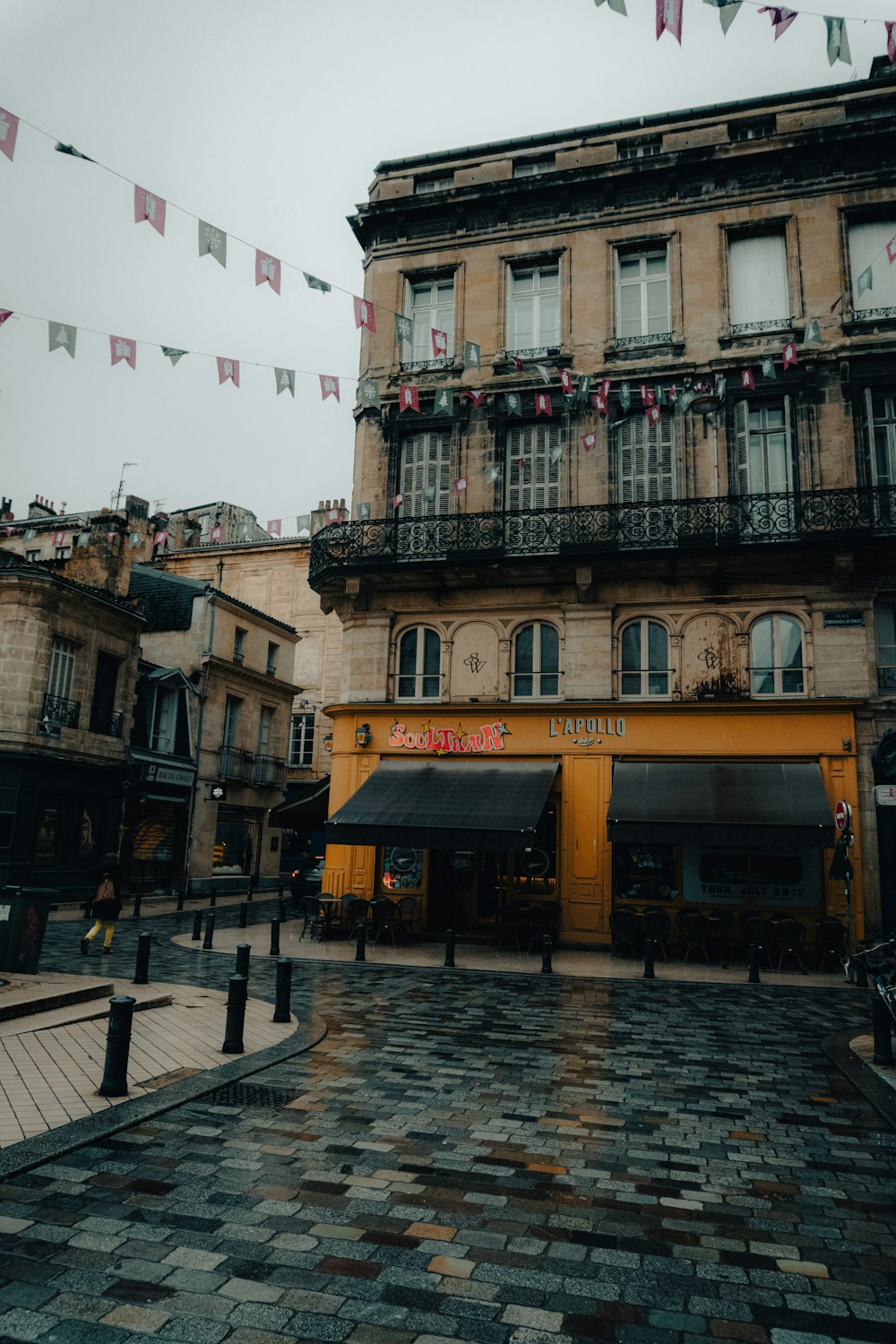 a building with a lot of flags hanging from it's balconies