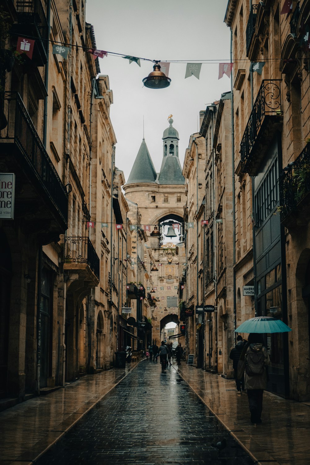 a couple of people walking down a street holding umbrellas