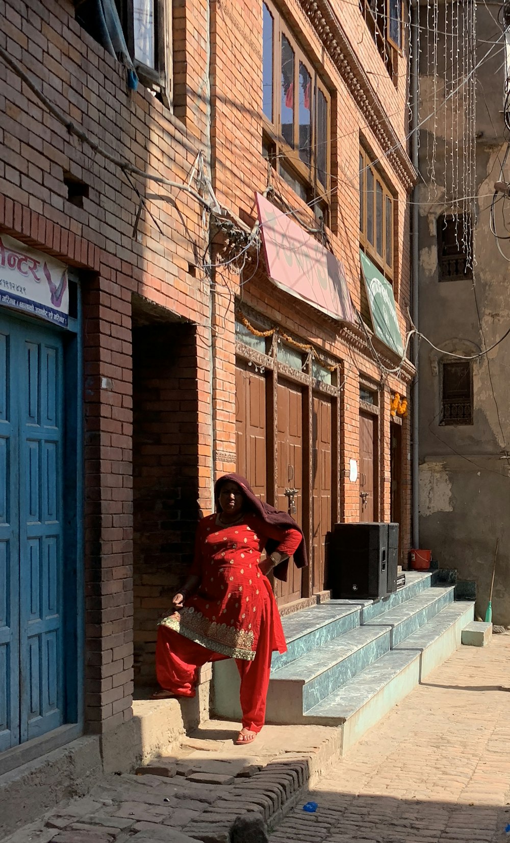 a woman in a red dress is walking down the street