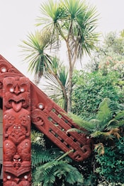 a red wooden structure in the middle of a forest