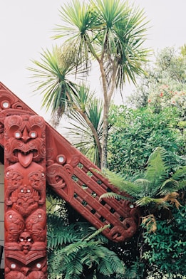 a red wooden structure in the middle of a forest