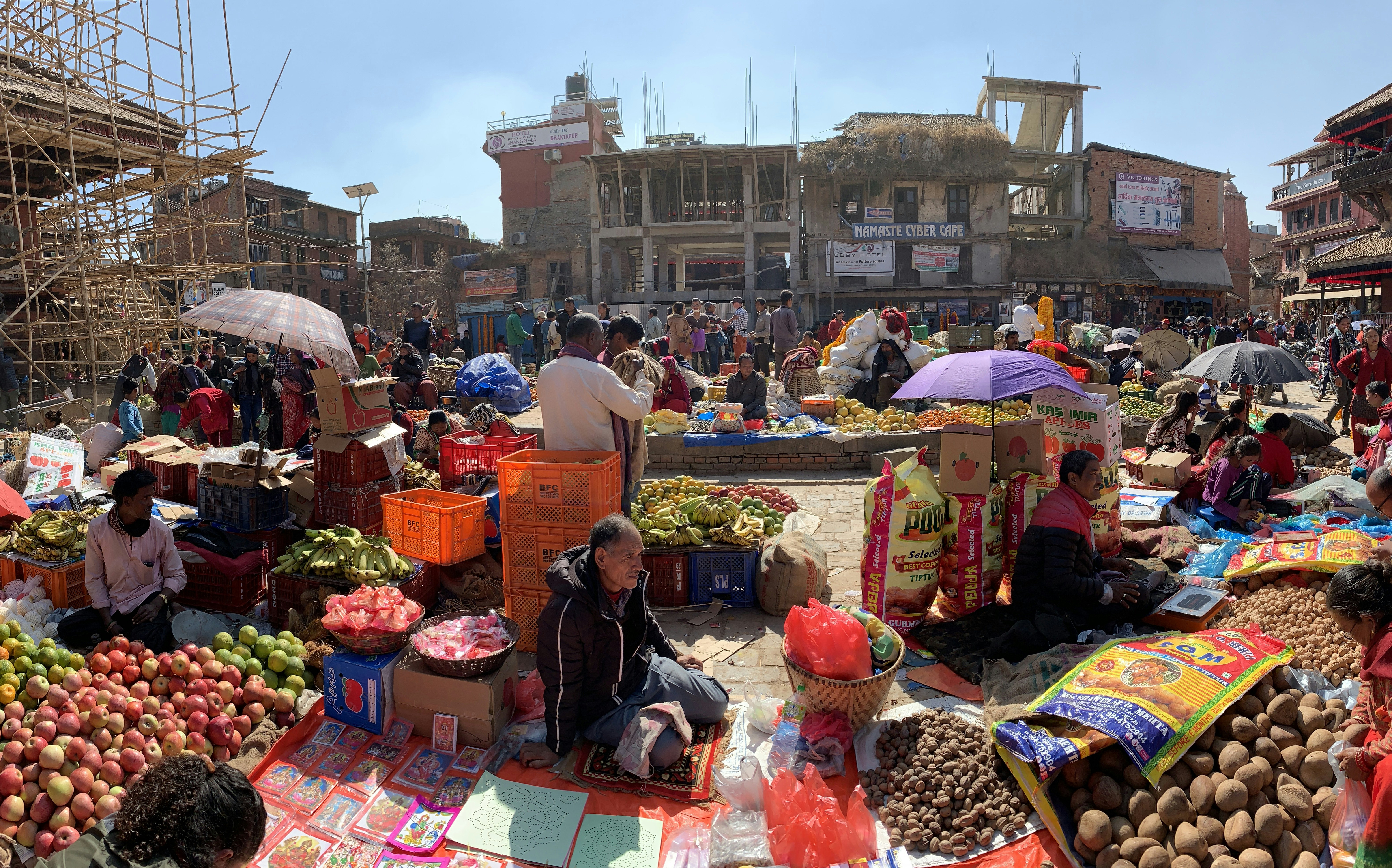 a group of people sitting on top of a pile of fruit