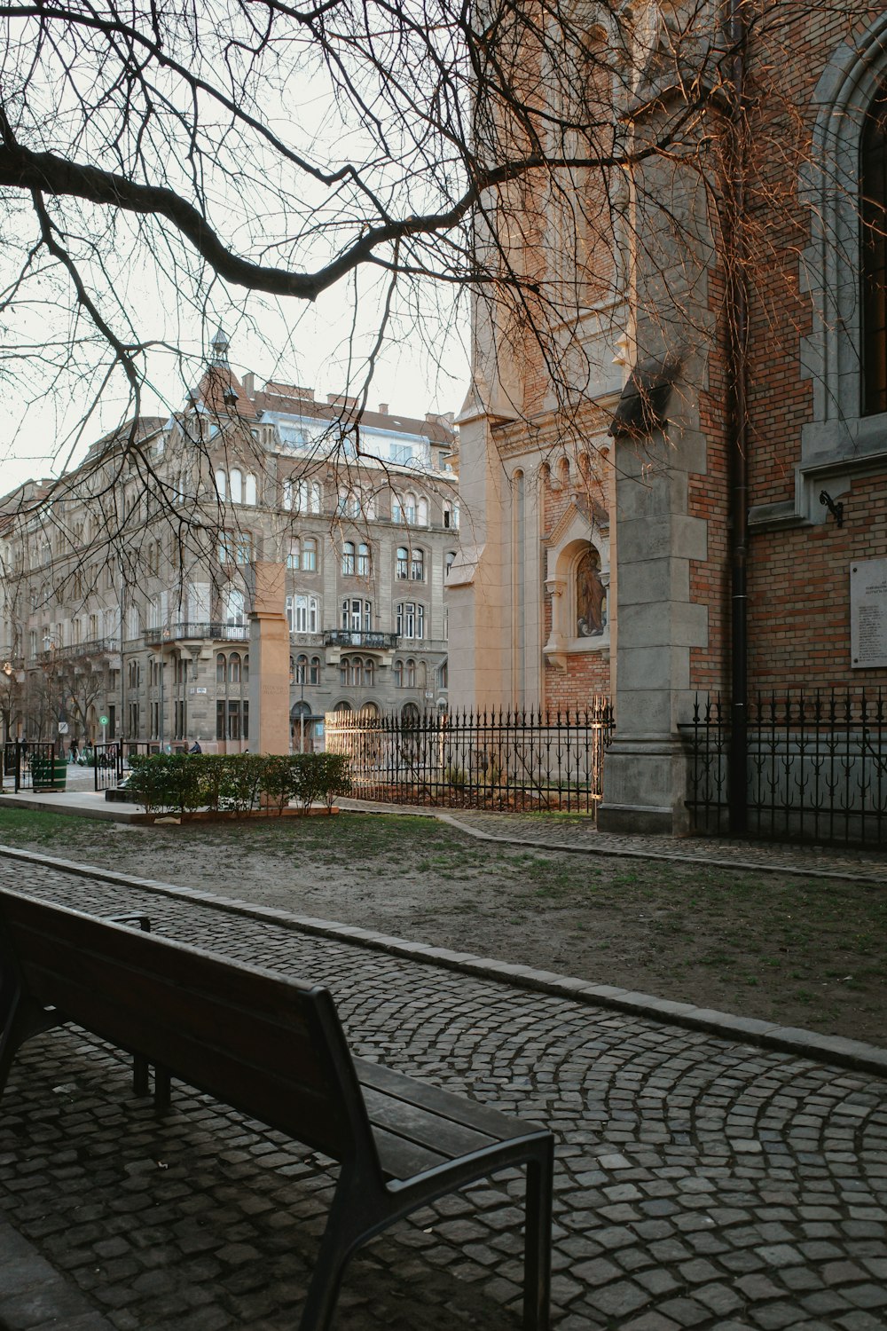 a wooden bench sitting in front of a tall building