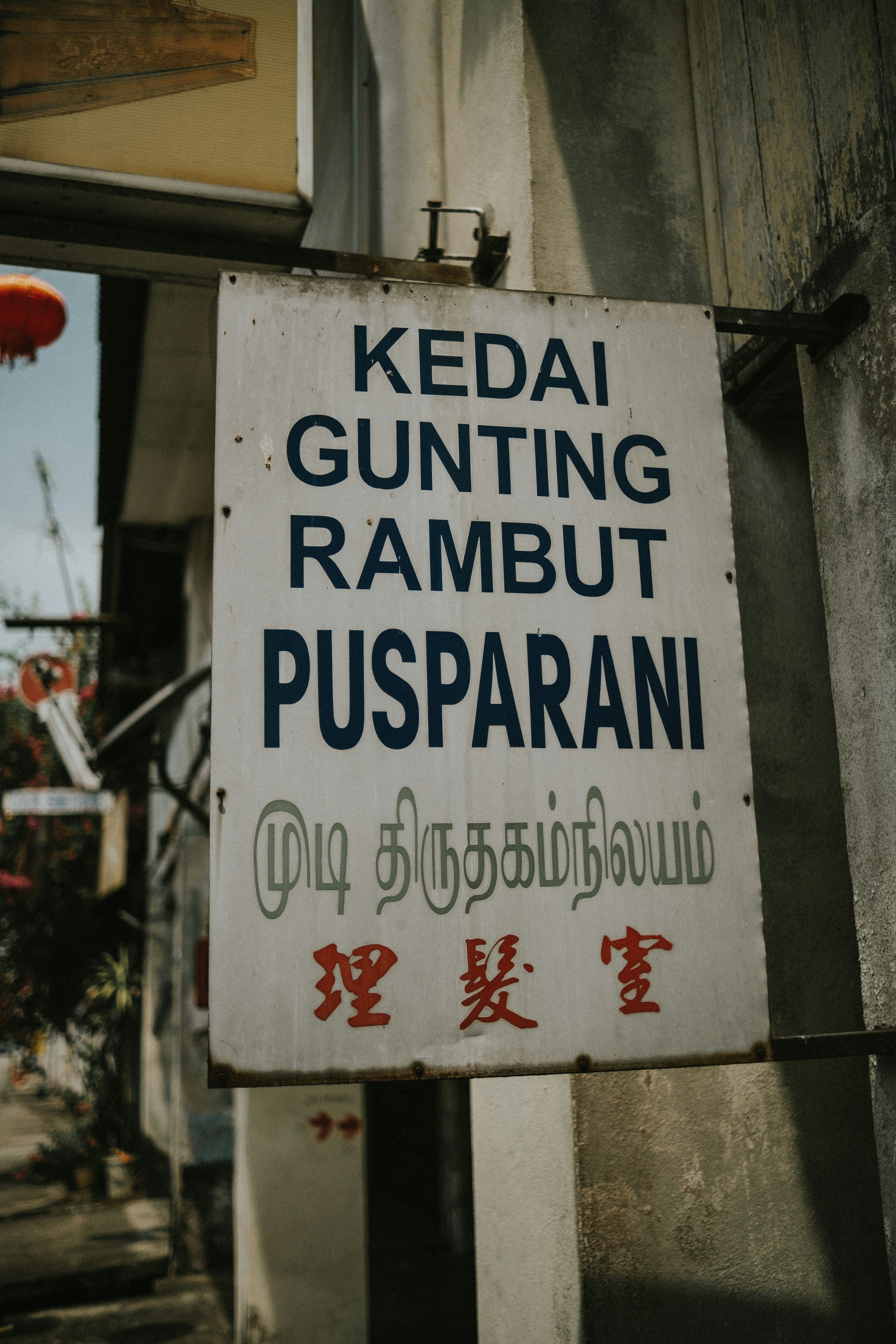 a sign on the side of a building that says kedai gunting rambu