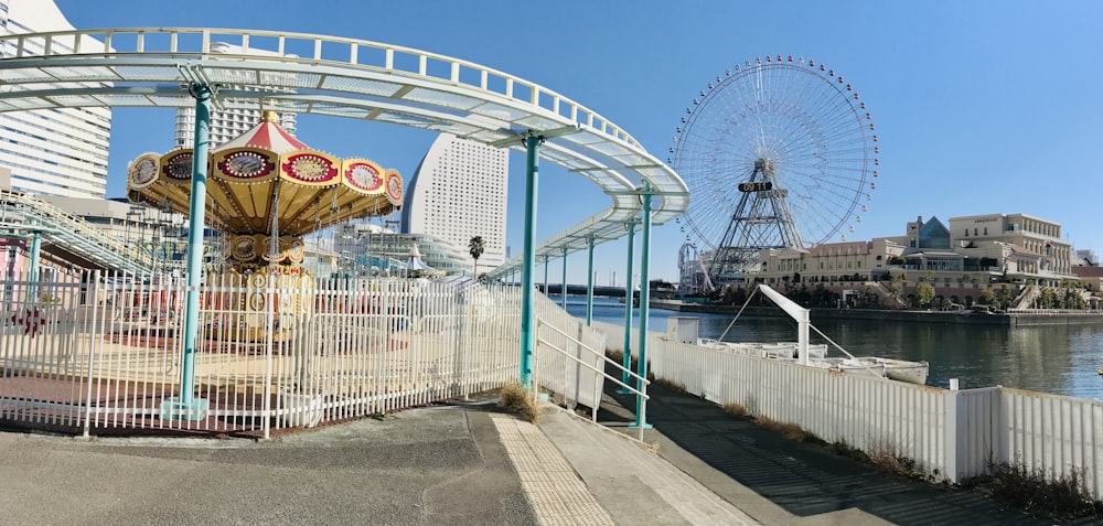 a ferris wheel sitting next to a white fence