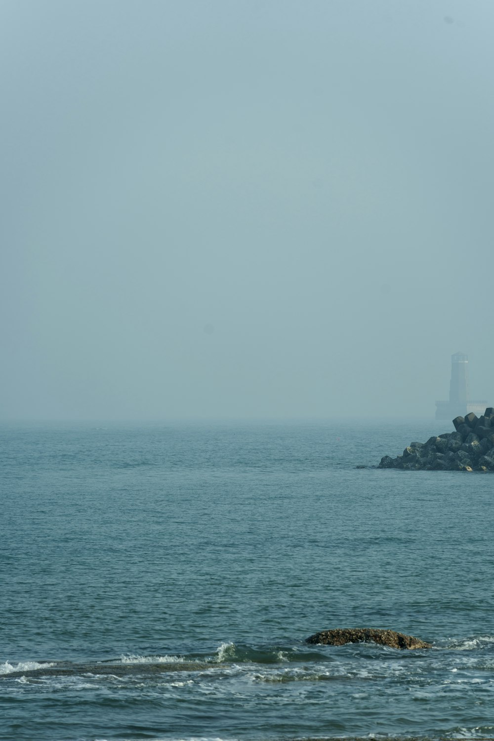 a large body of water with a lighthouse in the distance