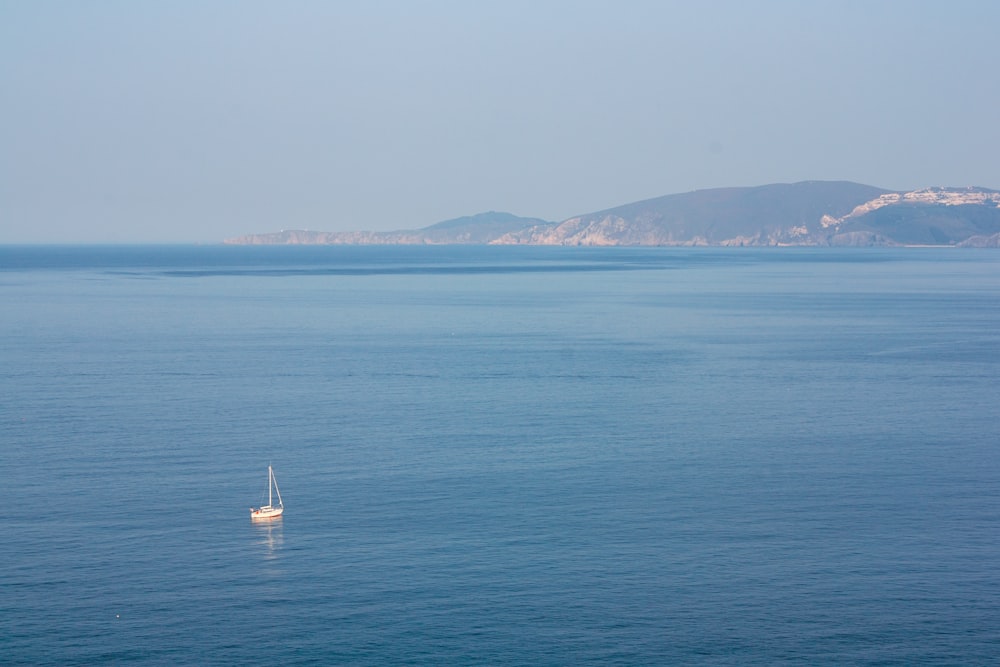 a boat floating in the middle of a large body of water