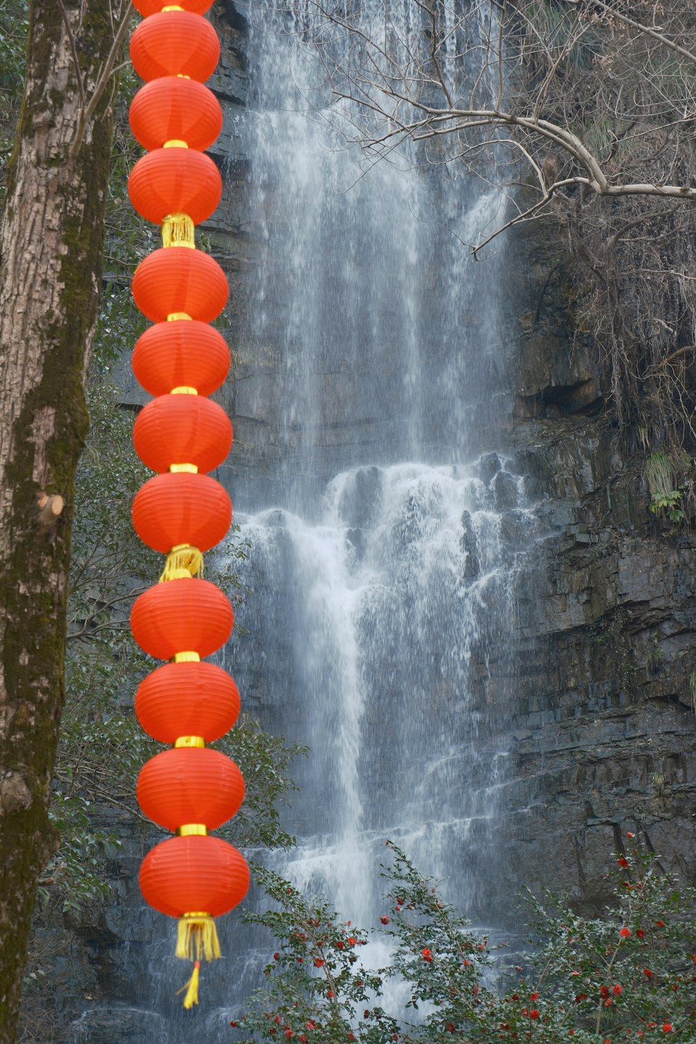 a waterfall with red lanterns hanging from it