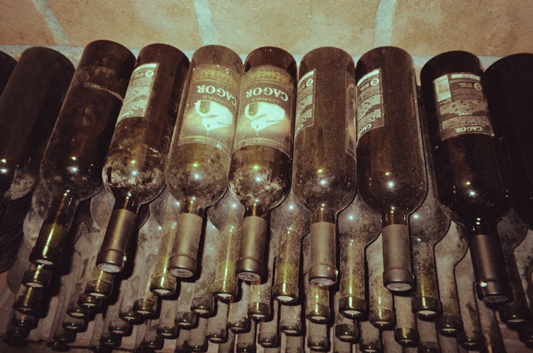 a bunch of wine bottles lined up in a row,