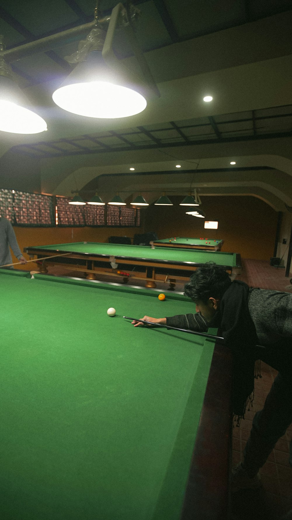 two people playing pool in a large room