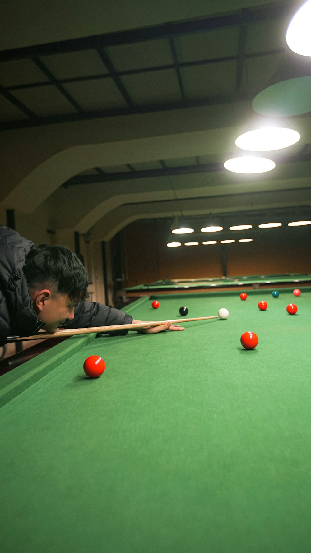 a man is leaning over a pool table