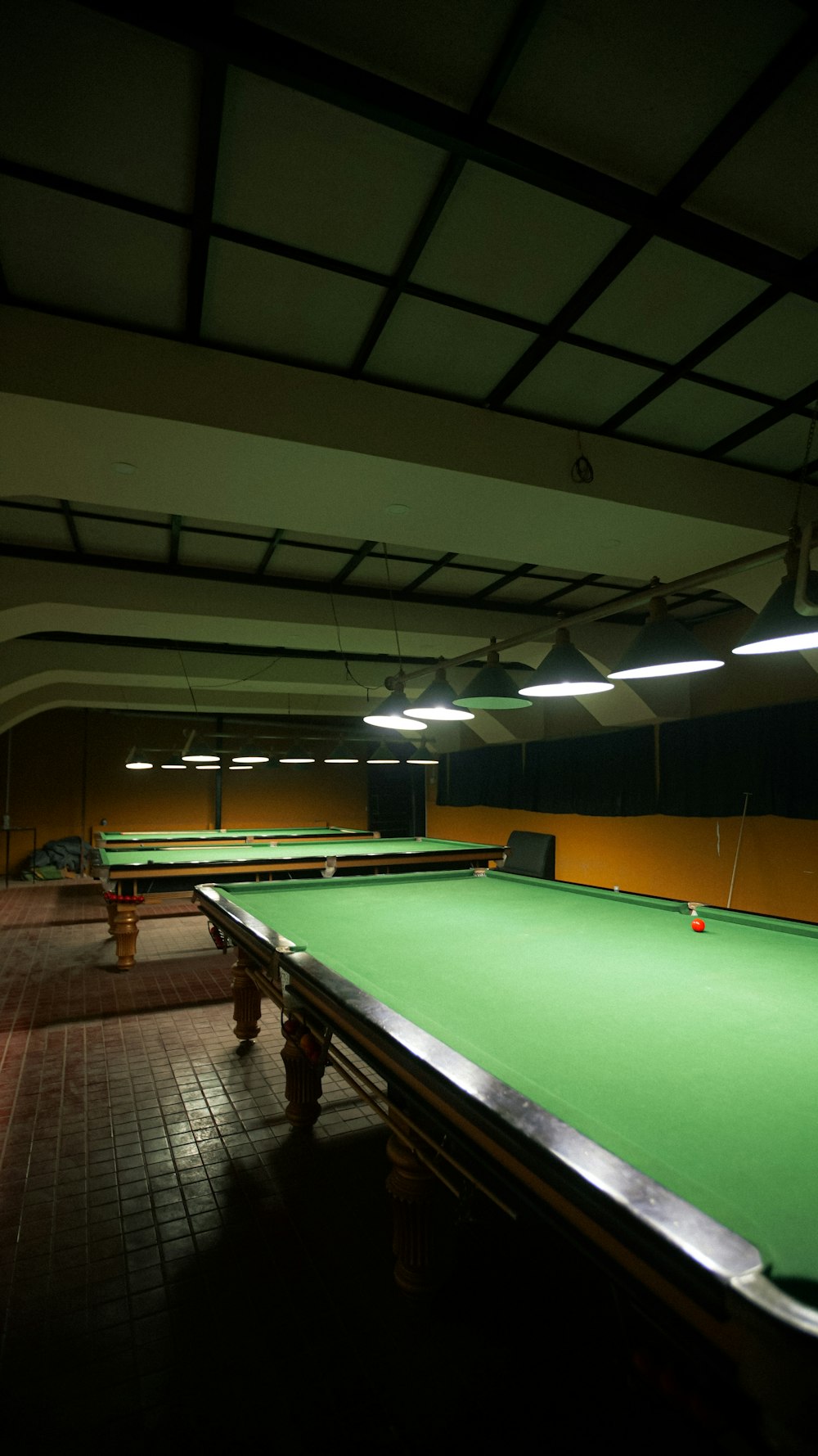 a green pool table in a dark room