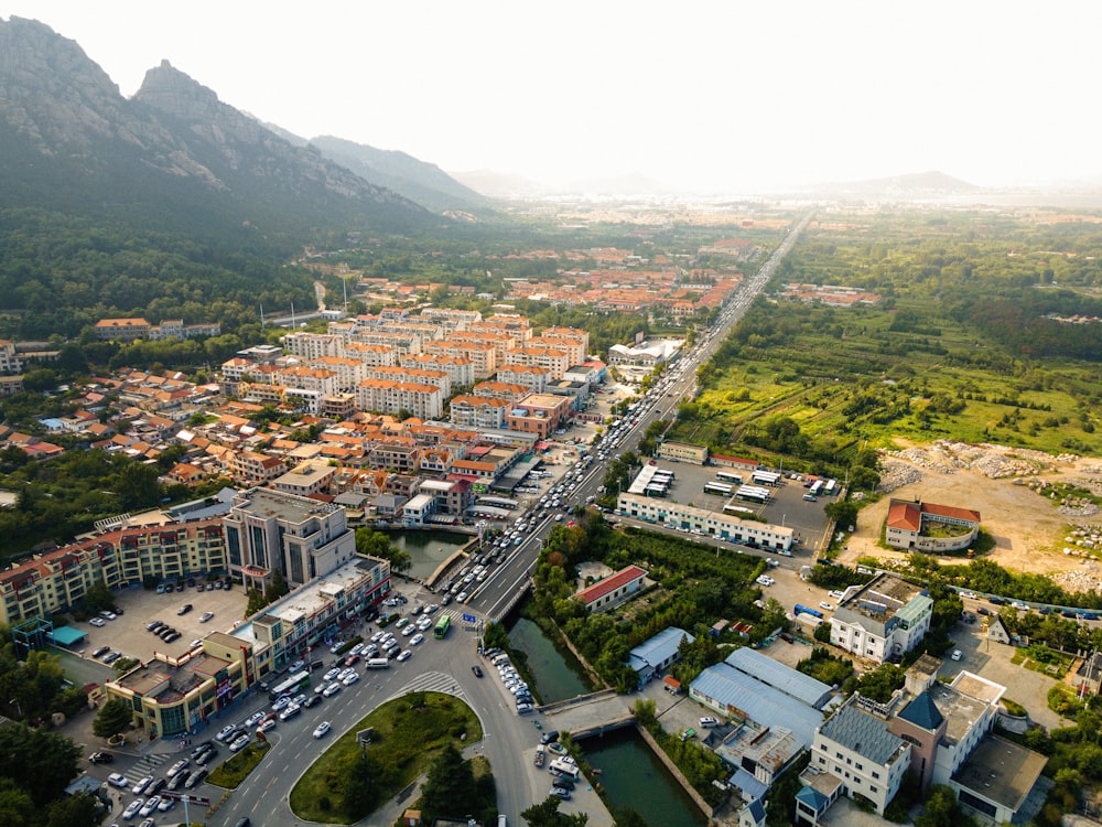 an aerial view of a city with mountains in the background