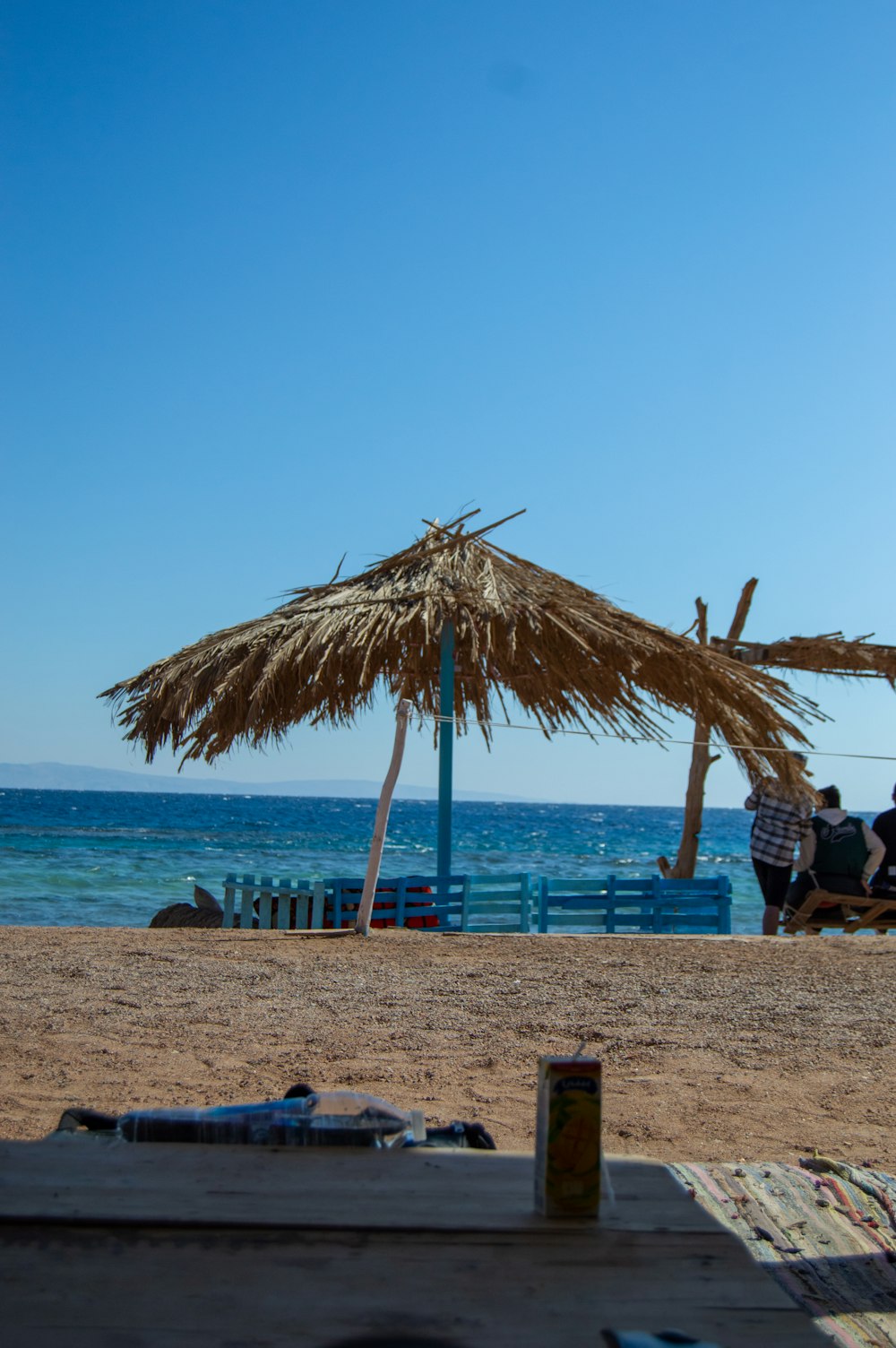 a straw umbrella sitting on top of a sandy beach