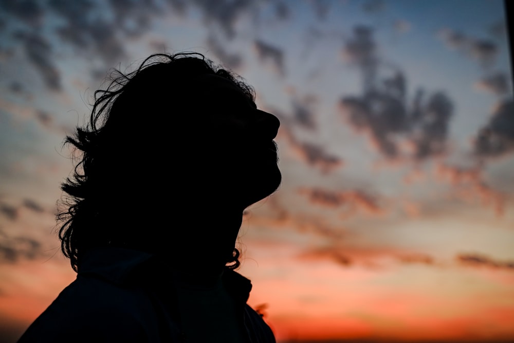 a silhouette of a person in front of a sunset