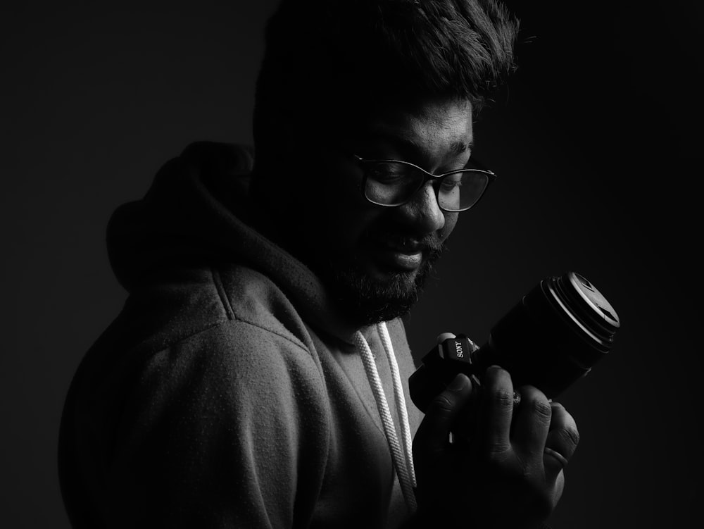 a man in a hoodie holding a camera