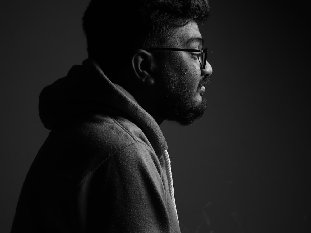 a black and white photo of a man in a hoodie