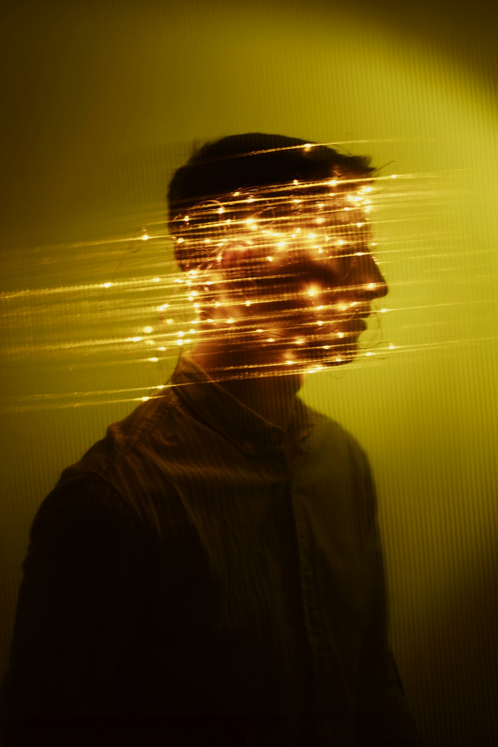 a man standing in front of a yellow light